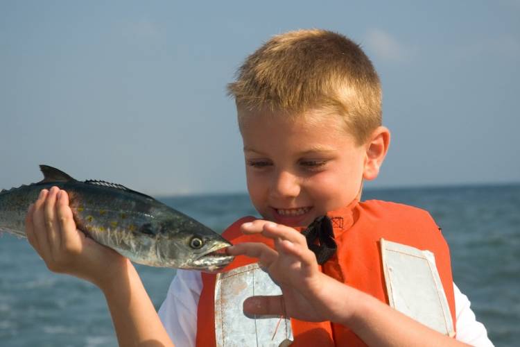 Kid holding Spanish mackerel on fishing charter