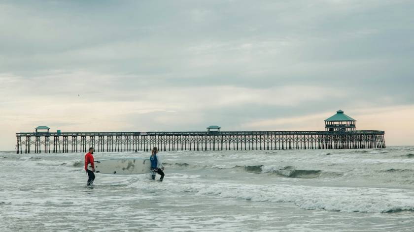 surfers near the folly beach pier